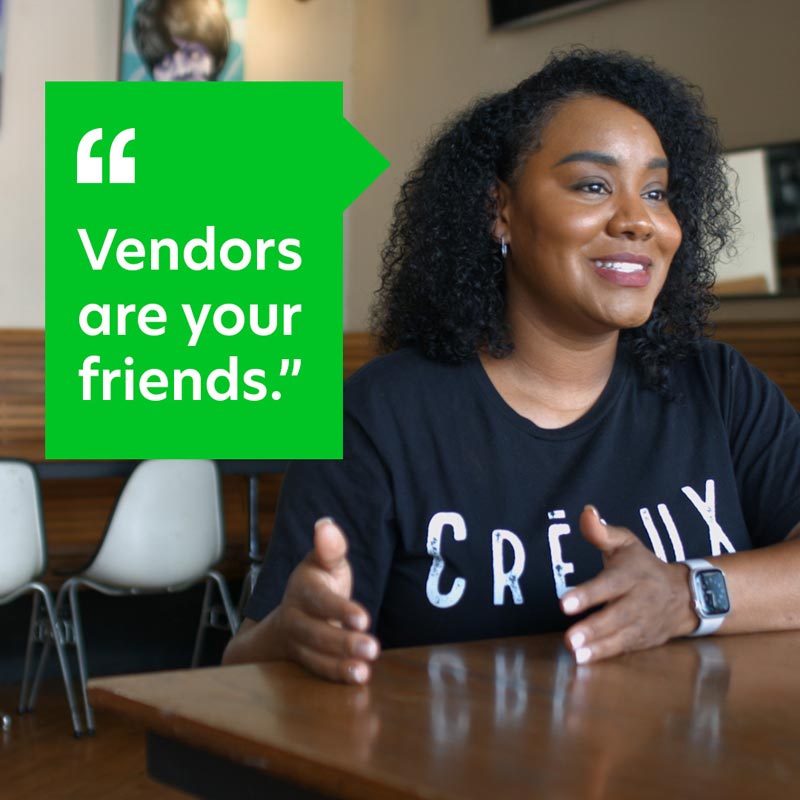 Small Business owner Ieasha Allen sits at a table talking about how to keep track of your business expenses, with quote 'Vendors are your friends' appearing on the image.