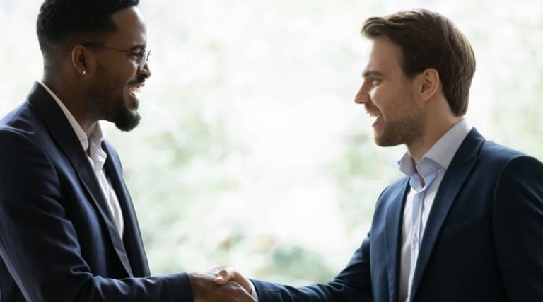 Multiracial businessmen shaking hands in doorway